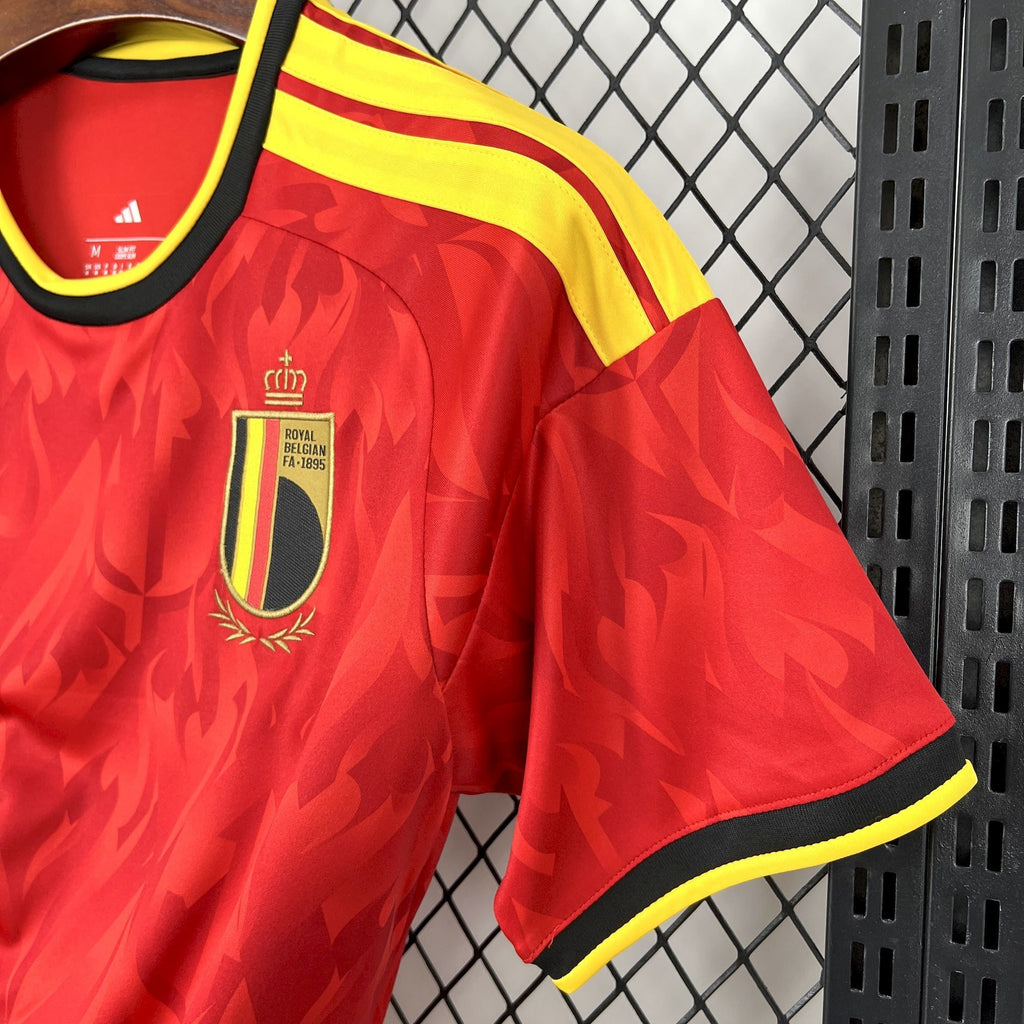 Red soccer jersey shoulder and crest area with yellow trim and black details