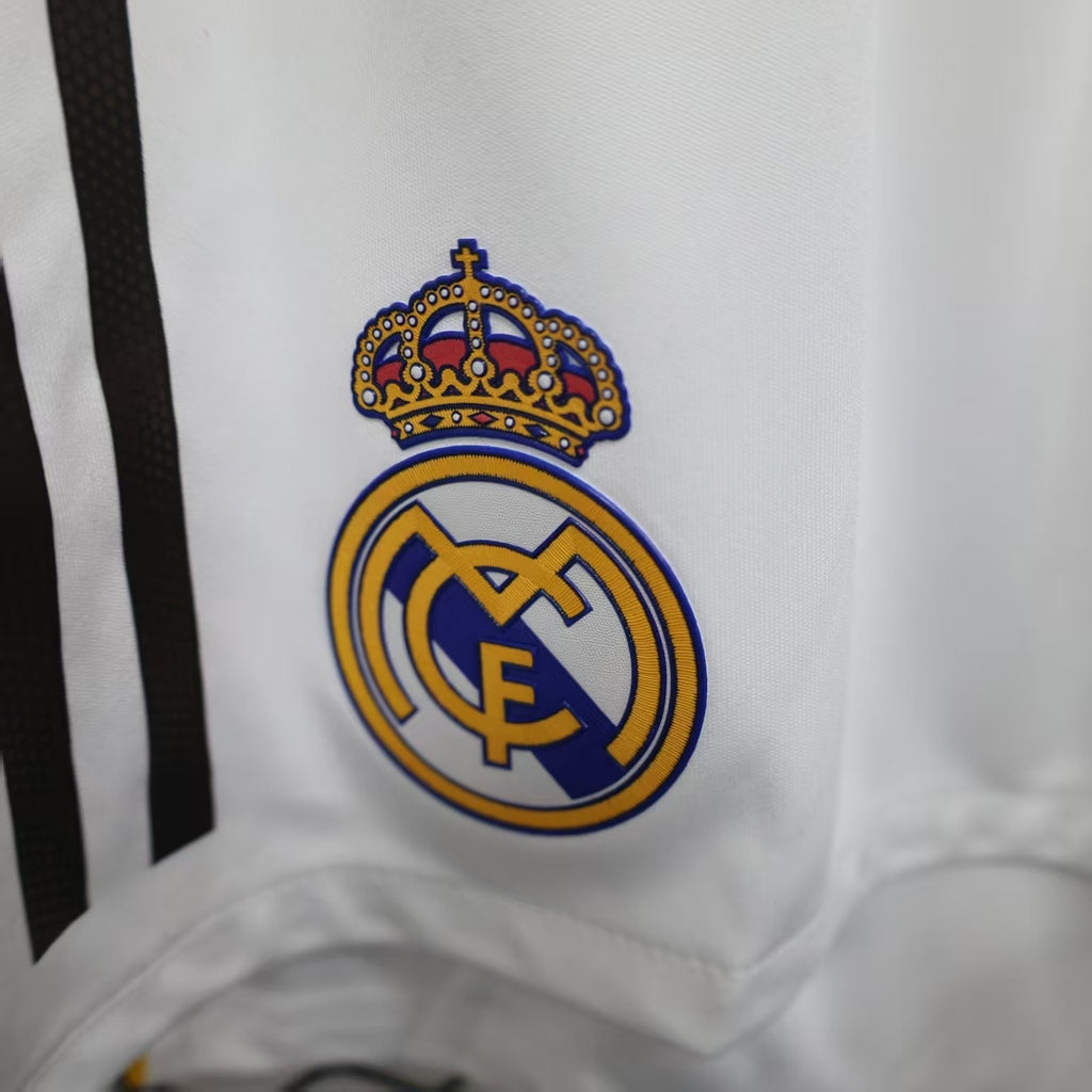 White shorts with Real Madrid crest patch and embroidered crown detail.