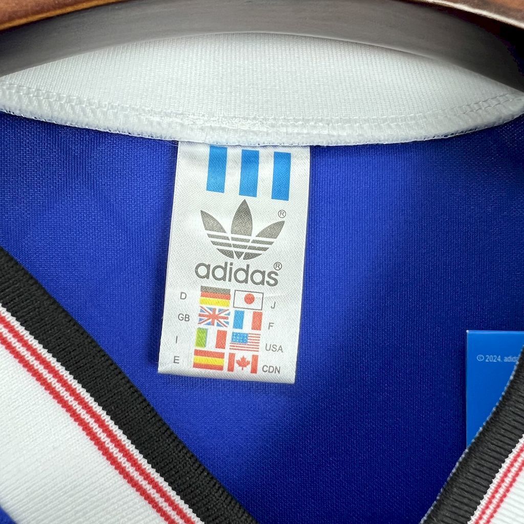 Blue football shirt collar with adidas label and black plus red trim