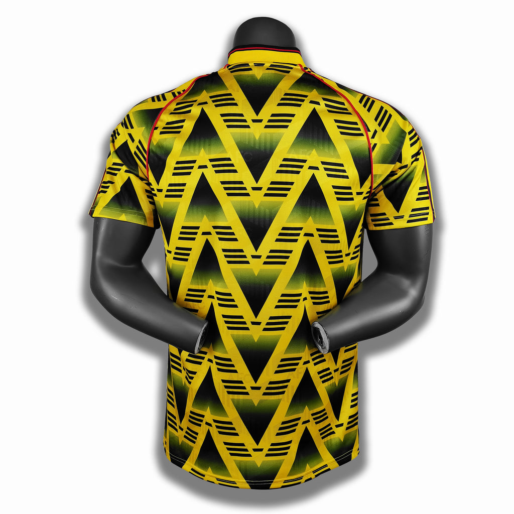 Yellow football jersey with black zigzag stripes and red-and-black collar trim