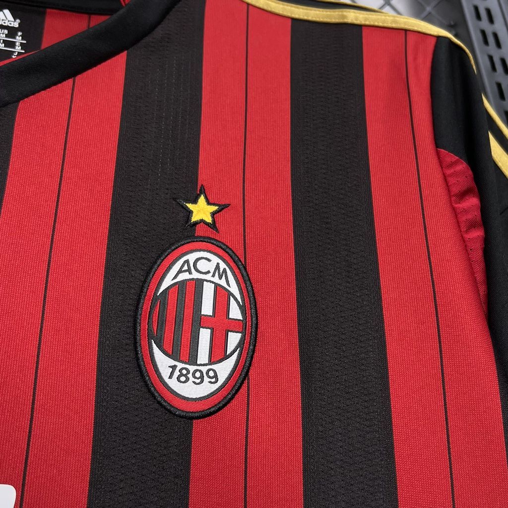AC Milan club crest on red-and-black striped jersey front with small gold star above