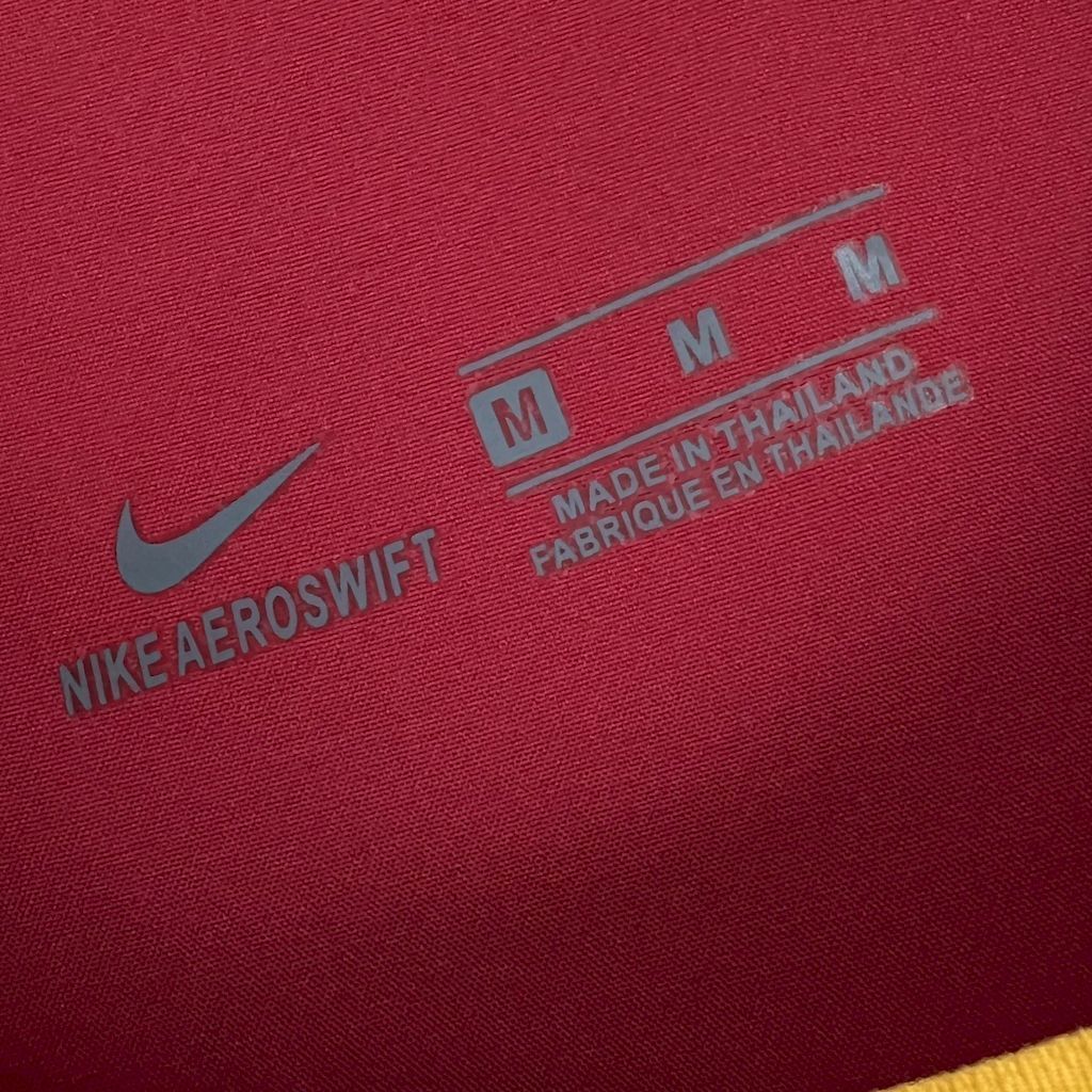Red fabric label with Nike AEROSWIFT and size M; Made in Thailand, fabrique en