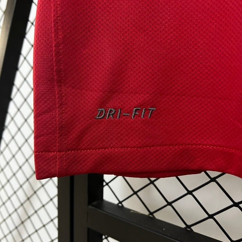 Red soccer jersey hem close-up with “DRI-FIT” branding on fabric