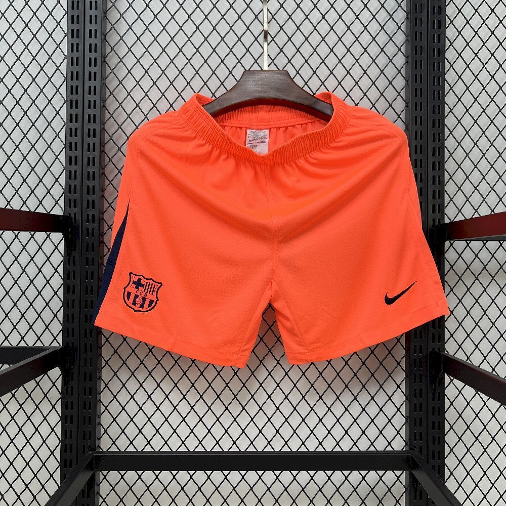 Orange FC Barcelona fan shorts with crest and Nike swoosh, hanging