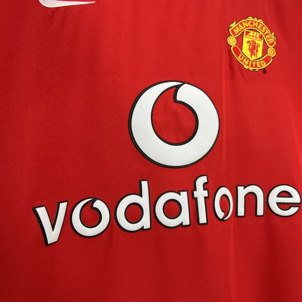 Red football shirt: Vodafone sponsor logo print and Manchester crest badge
