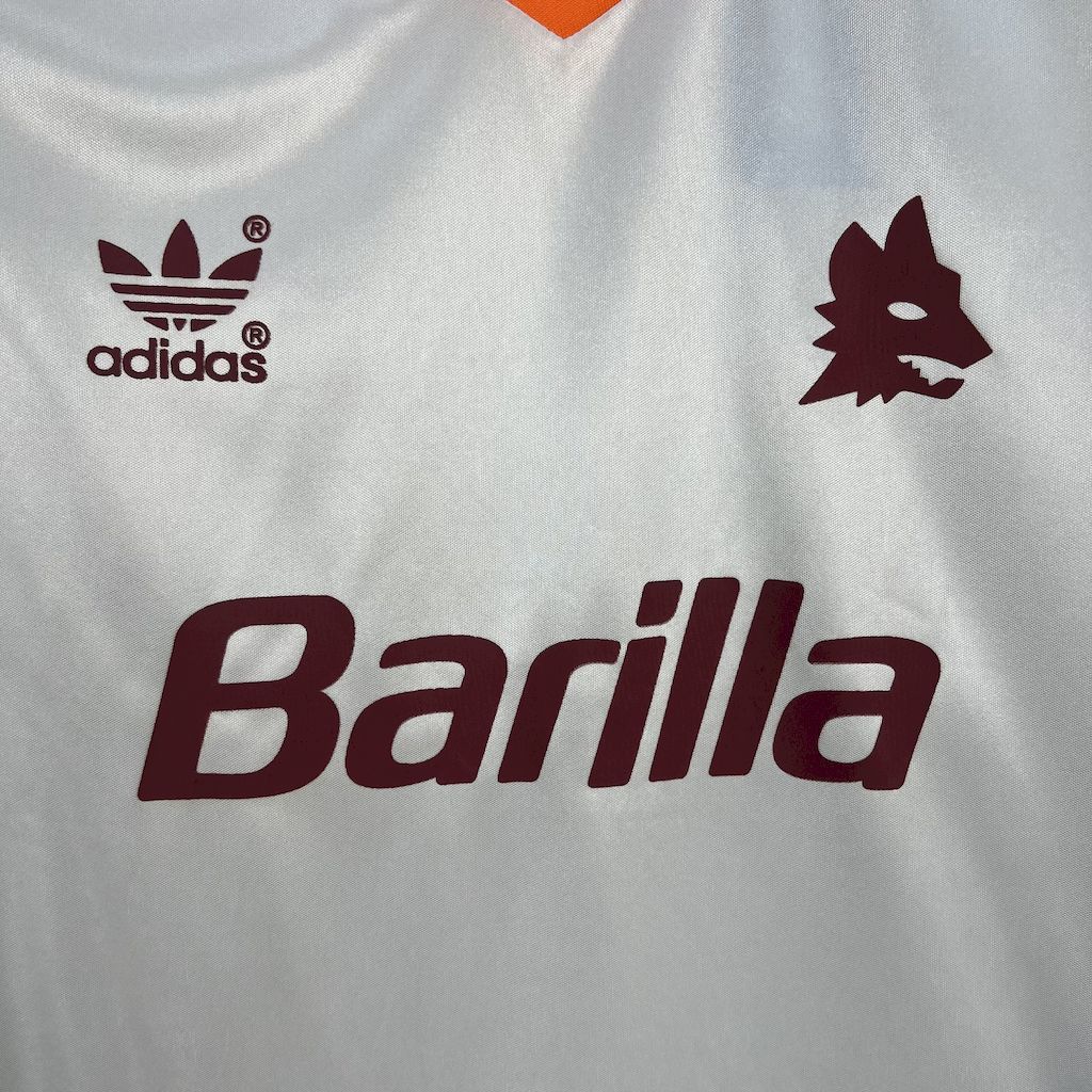 White soccer jersey closeup with adidas logo, maroon crest, large Barilla sponsor