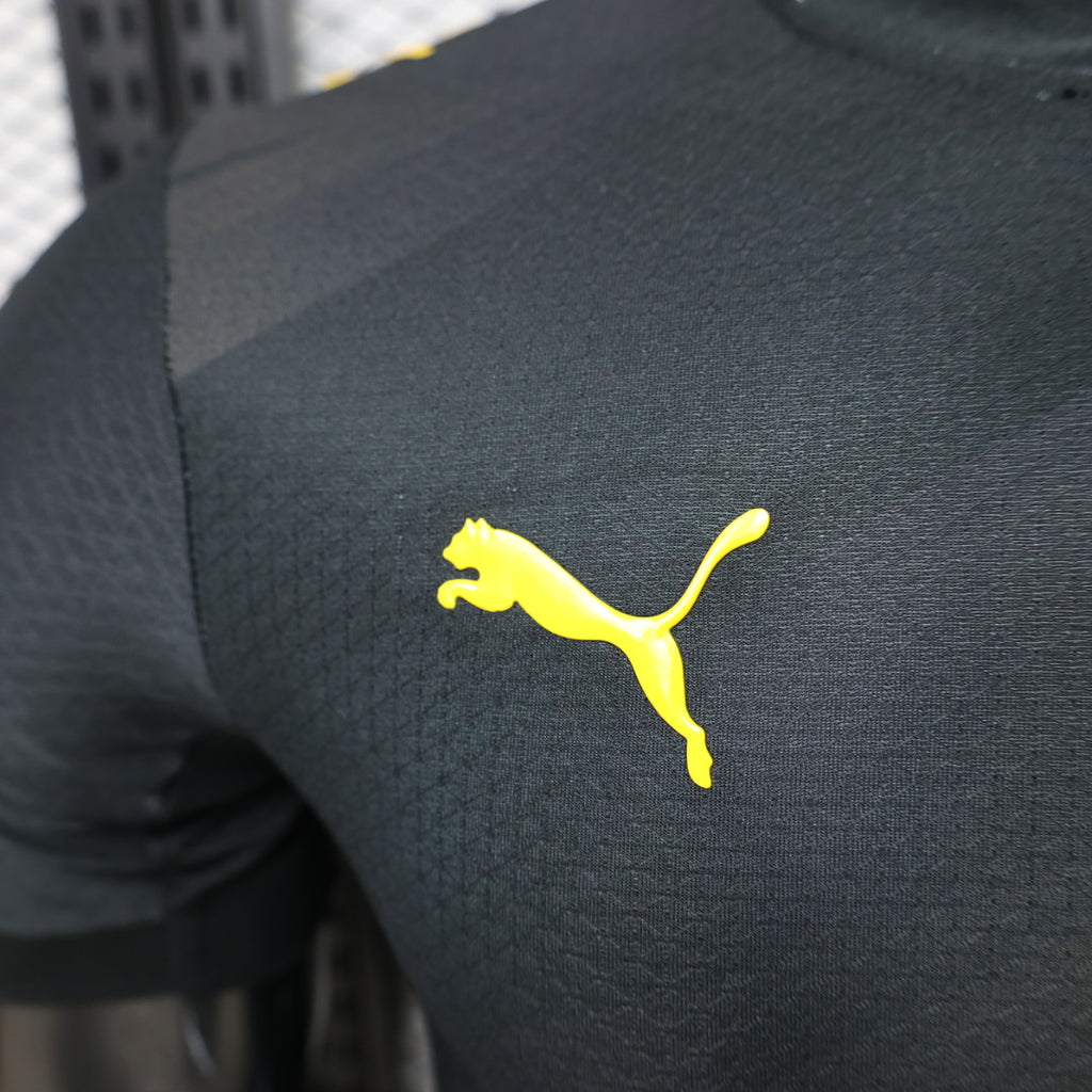 Borussia Dortmund away football jersey (player version) featuring yellow PUMA cat logo on dark fabric