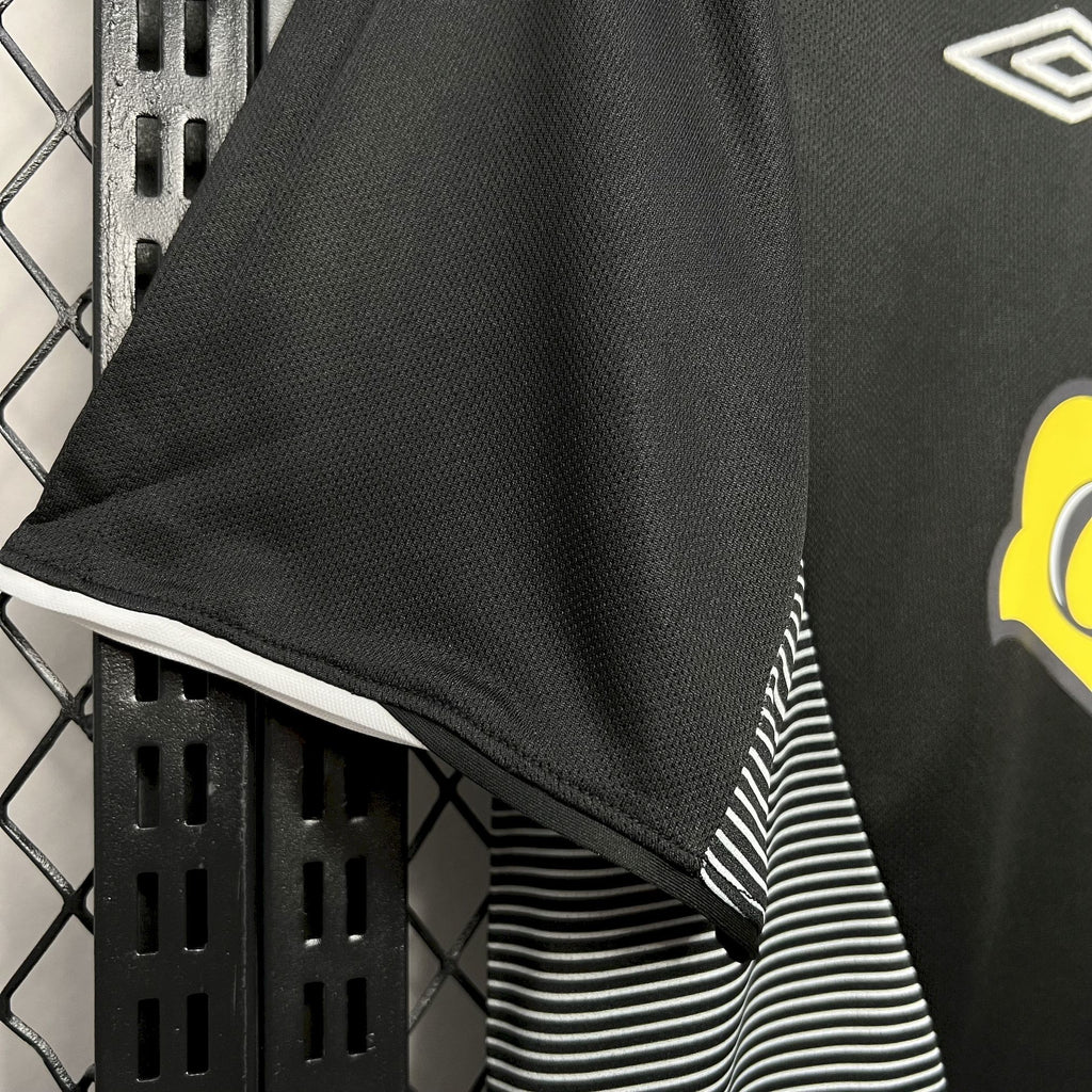Black football jersey with striped side panel and partial yellow Cristal graphic