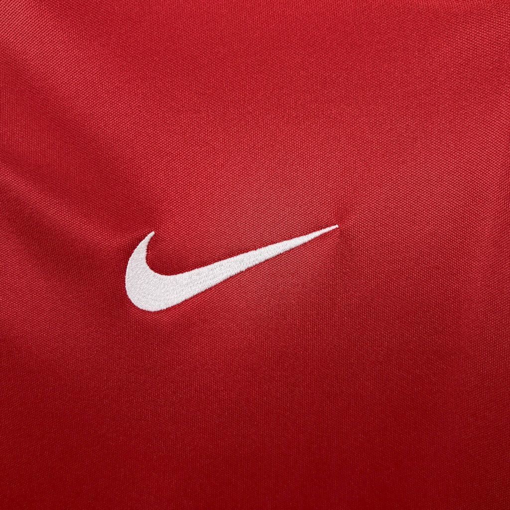 White Nike swoosh logo on red retro soccer jersey