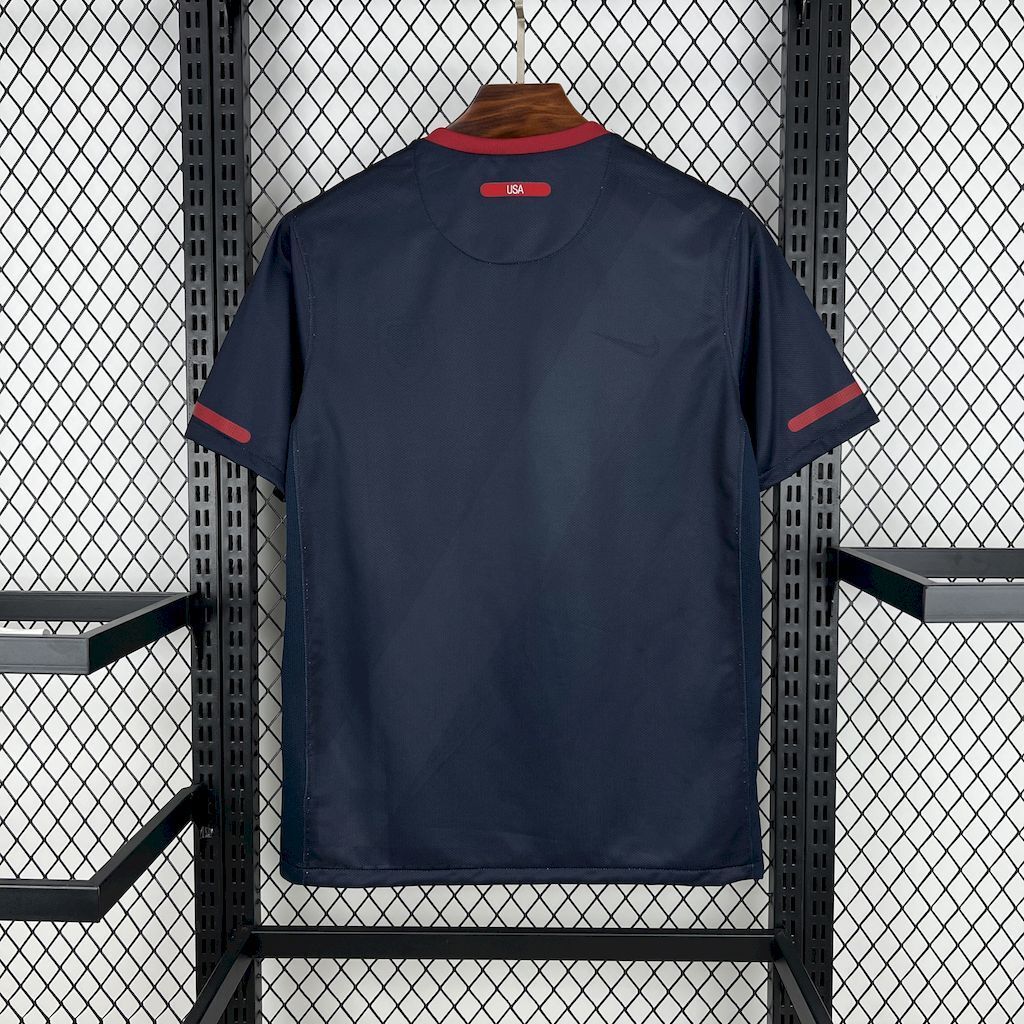 Navy away soccer jersey with red collar and sleeve cuffs, back view.