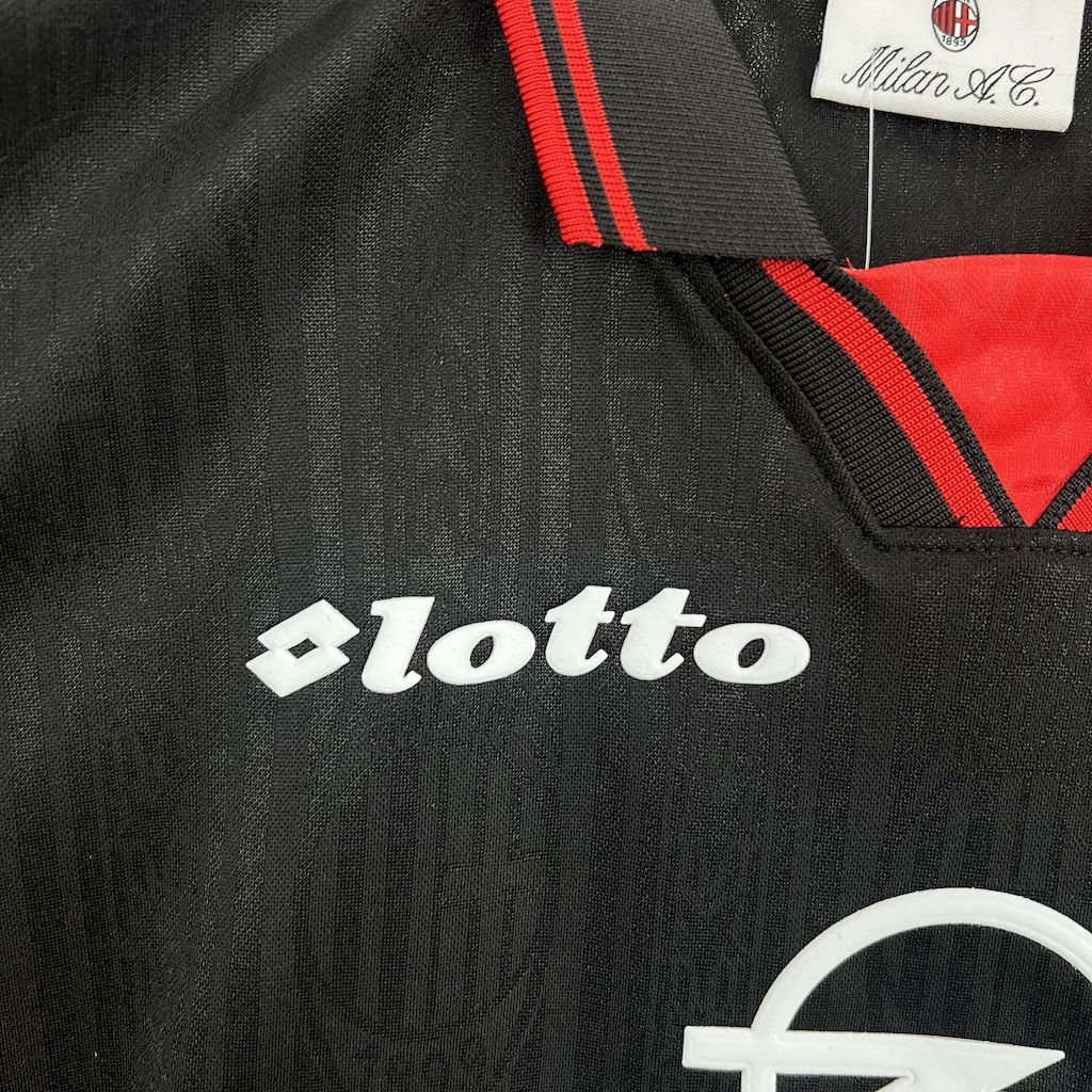 Black jersey close-up: lotto logo with red-and-black shoulder stripes