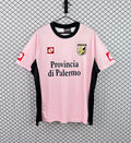 Pink Palermo home football jersey with black collar, crest badges, and Provincia di Palermo text