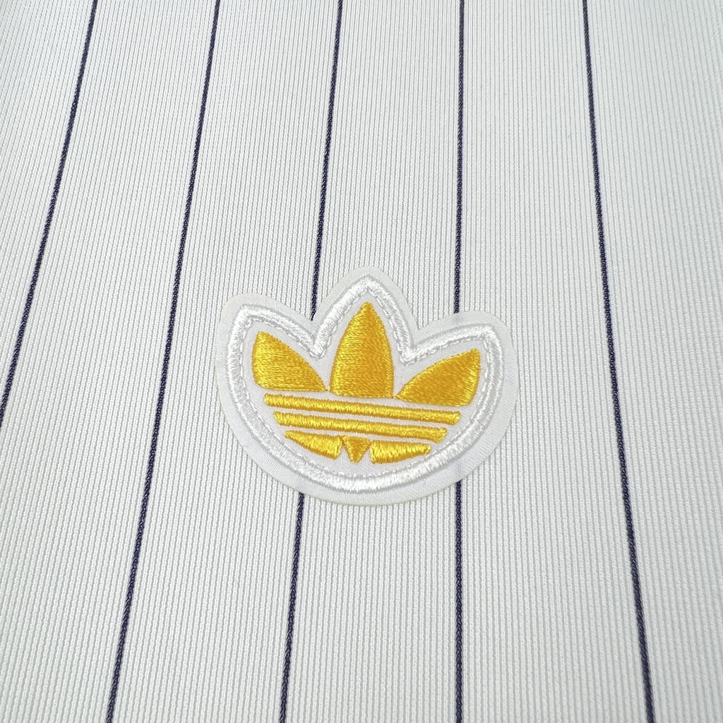 Gold crest applique on white pinstripe soccer shirt fabric close-up