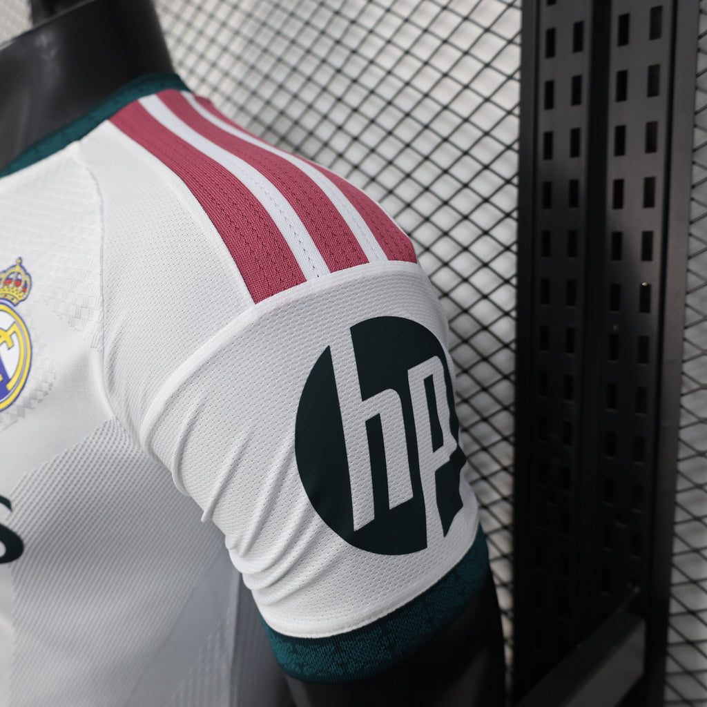 White football jersey sleeve with maroon-and-teal stripes and black sponsor logo