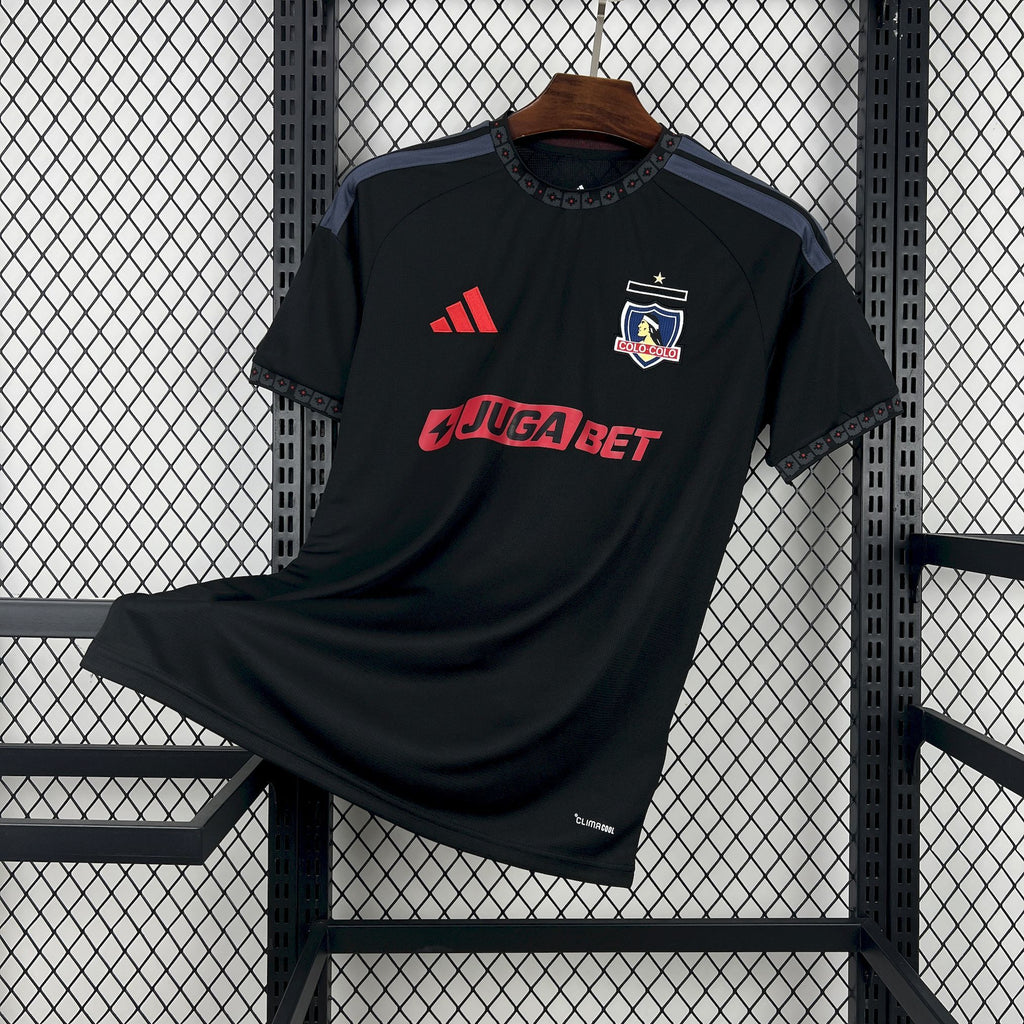 Black away football jersey with crest, Adidas logo, and red 'JUGABET' chest print