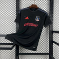 Black away football jersey with crest, Adidas logo, and red 'JUGABET' chest print