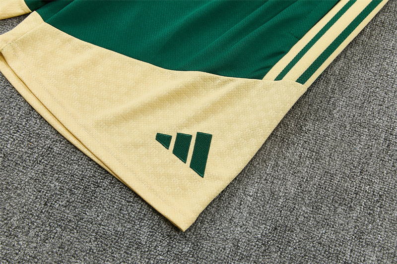 Green and cream shorts with adidas logo and side stripes at hem