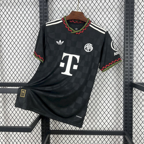 Black football jersey with red and green trim, FC Bayern crest, and white sponsor logo.