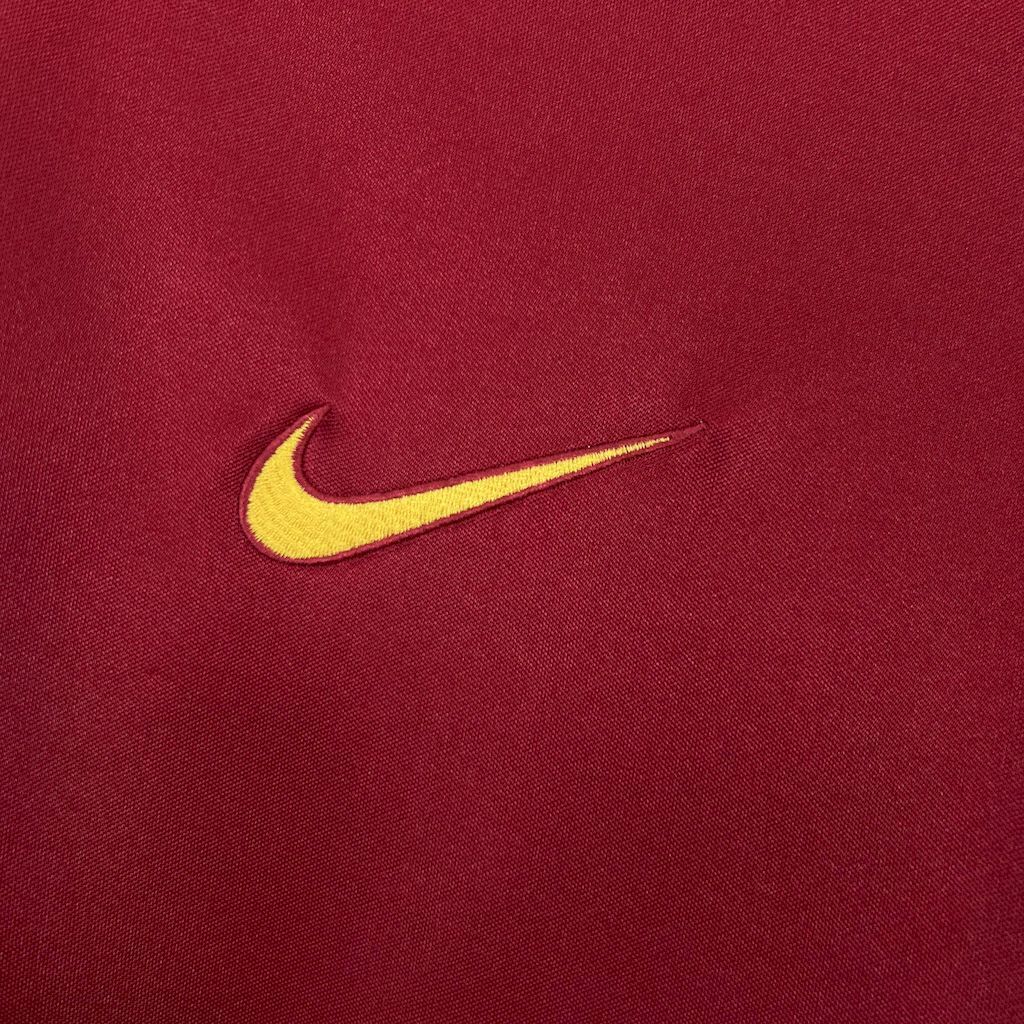 Yellow Nike swoosh logo on maroon football jersey