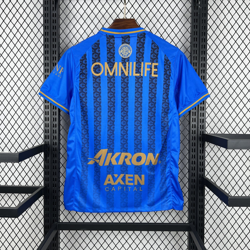 Blue soccer jersey back view with vertical stripes and large gold sponsor lettering
