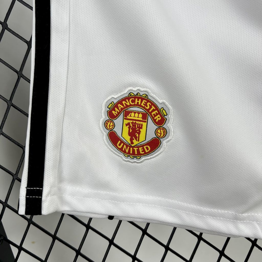 Kids white shorts close-up with Manchester United crest patch on front leg