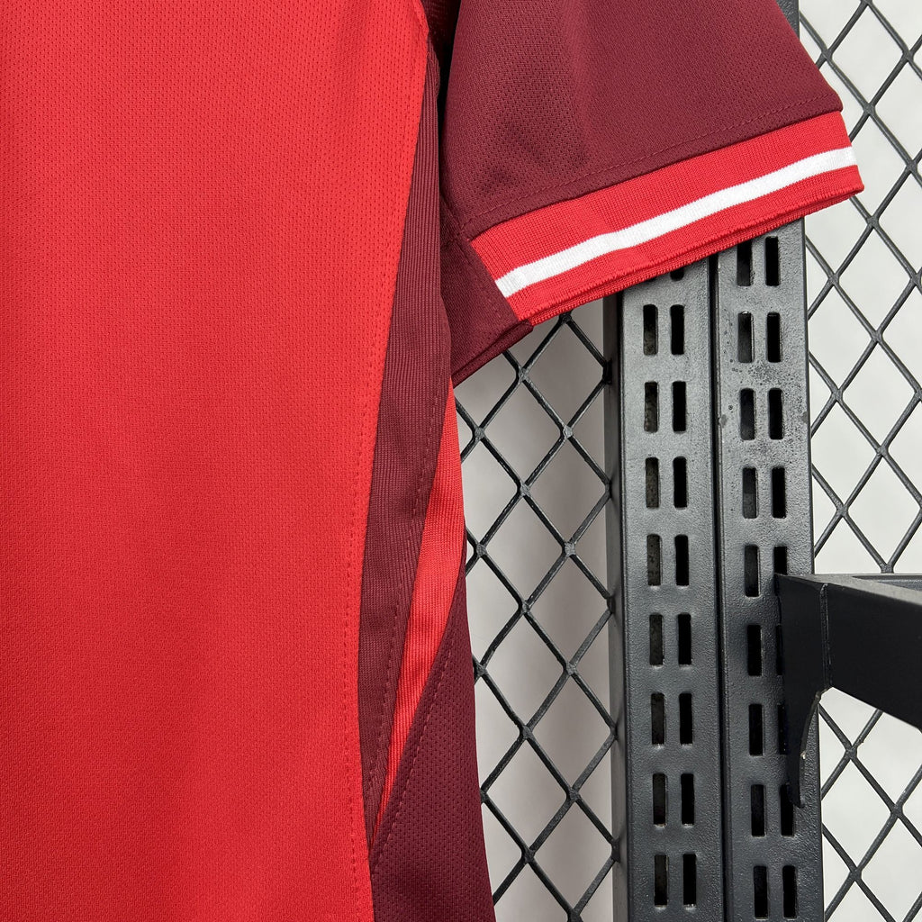 Red soccer jersey sleeve cuff with white and darker red striped band trim.