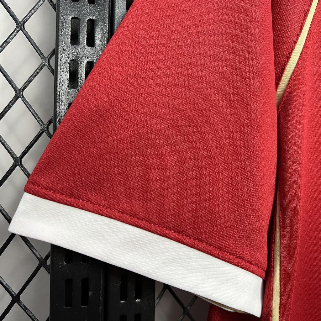 Red jersey sleeve cuff with white trim and yellow piping