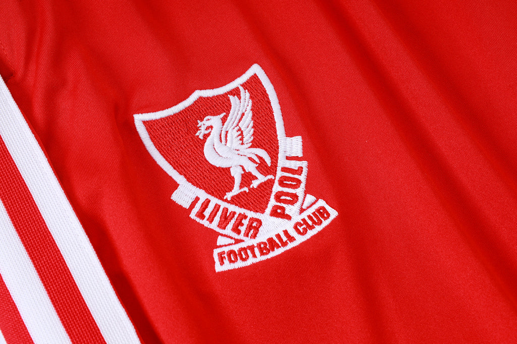 Red training top chest crest with white sleeve stripes and Liverpool Football Club logo.