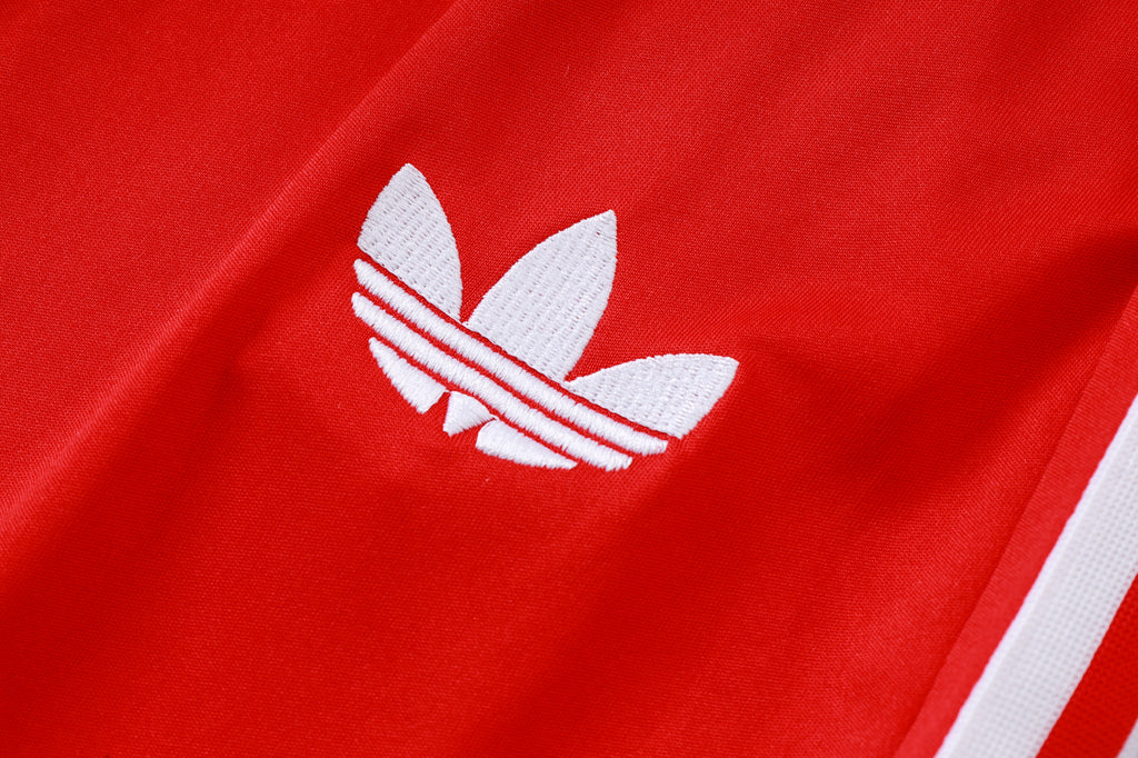 Red top with white adidas trefoil logo and three white sleeve stripe details.