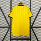 Yellow soccer jersey back view with black collar trim and side stripe accents