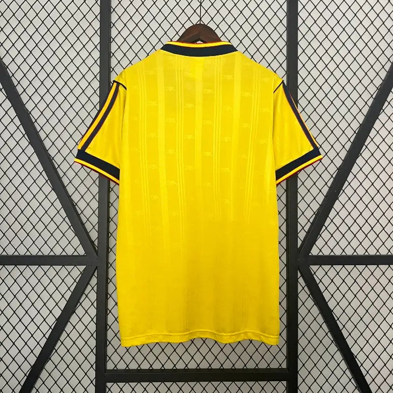 Yellow soccer jersey back view with black collar trim and side stripe accents