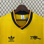 Yellow soccer jersey close-up: black V-neck collar, adidas logo, patch details
