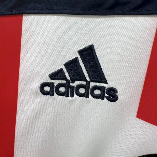 Retro football jersey fabric close-up with Adidas logo in black on white