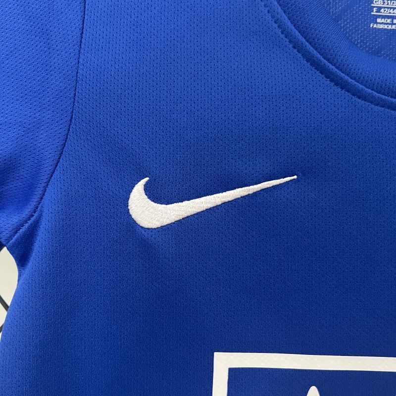 Blue kids jersey with white Nike swoosh and partial sponsor graphic