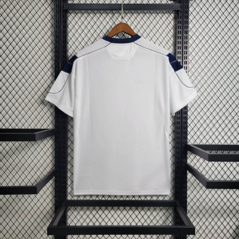 White retro soccer jersey with blue-trimmed shoulders and sleeves; no visible front print