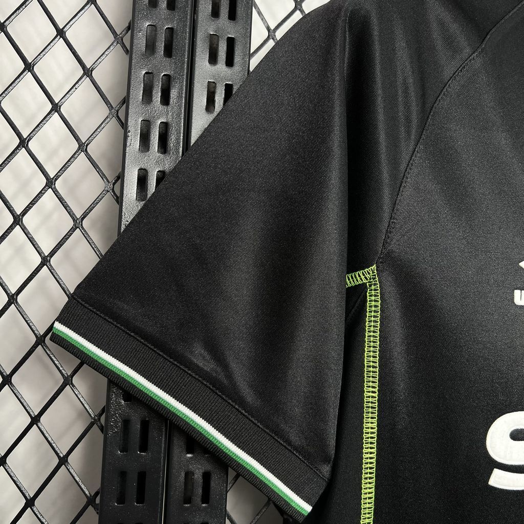 Black soccer jersey sleeve with green-and-white side stripe trim