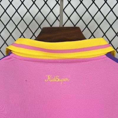 Pink goalkeeper jersey close-up with yellow striped collar and Kidsupero logo