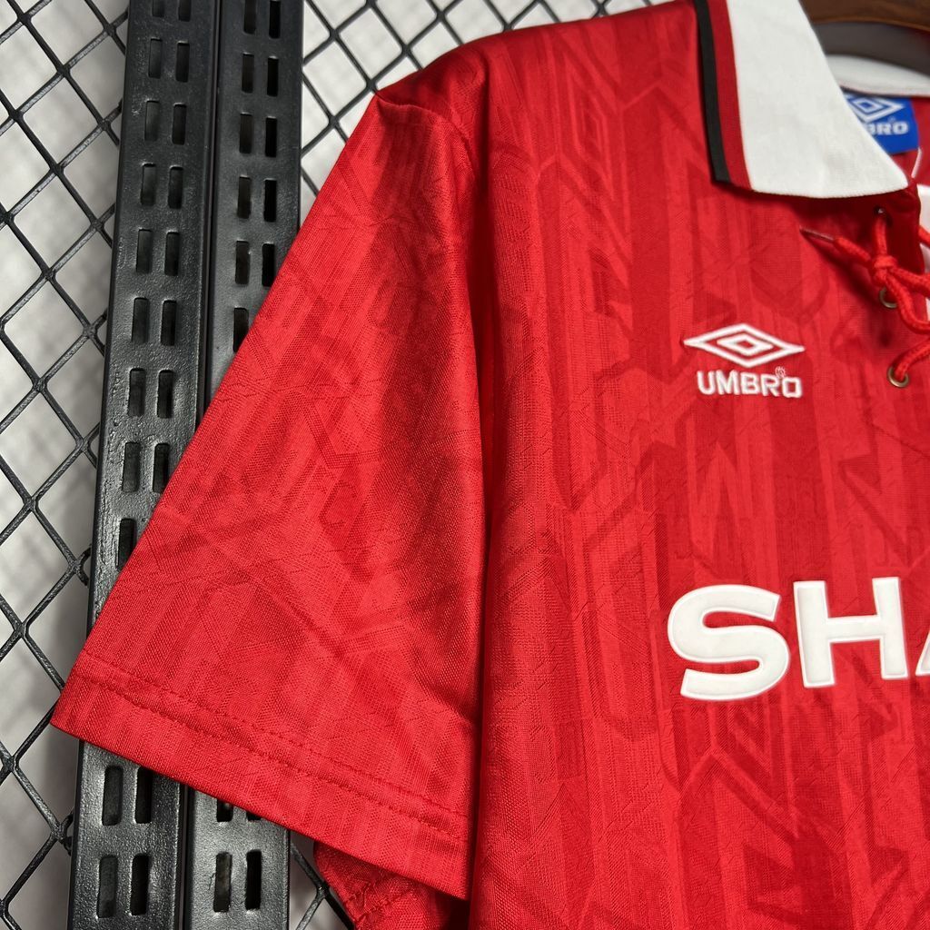 Red football jersey sleeve and hem with white collar, Umbro logo, and part of SHARP