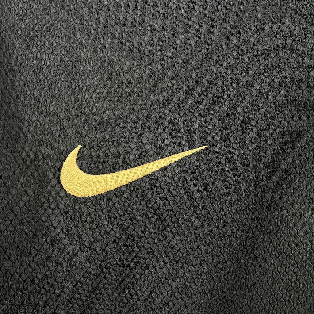 Yellow Nike swoosh logo on black textured jersey fabric