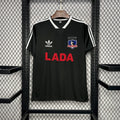 Black Colo-Colo away soccer jersey with adidas stripes, crest, and red 'LADA' sponsor