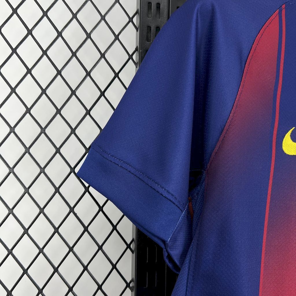 Barcelona home fan football jersey sleeve detail, blue fabric with red side stripe and seam