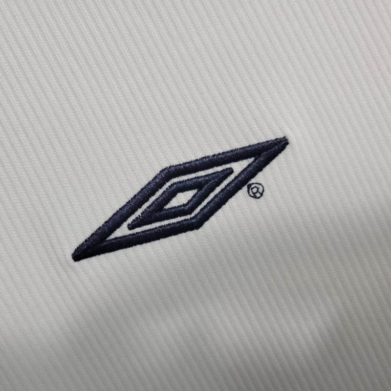 Close-up of blue Umbro logo on white jersey fabric
