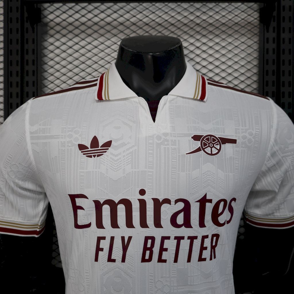 White football shirt with Emirates Fly Better sponsor and maroon team crests on chest