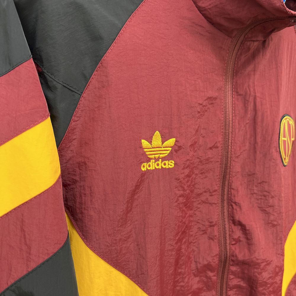 Maroon windbreaker front with adidas logo and zip, black and yellow sleeve trim.