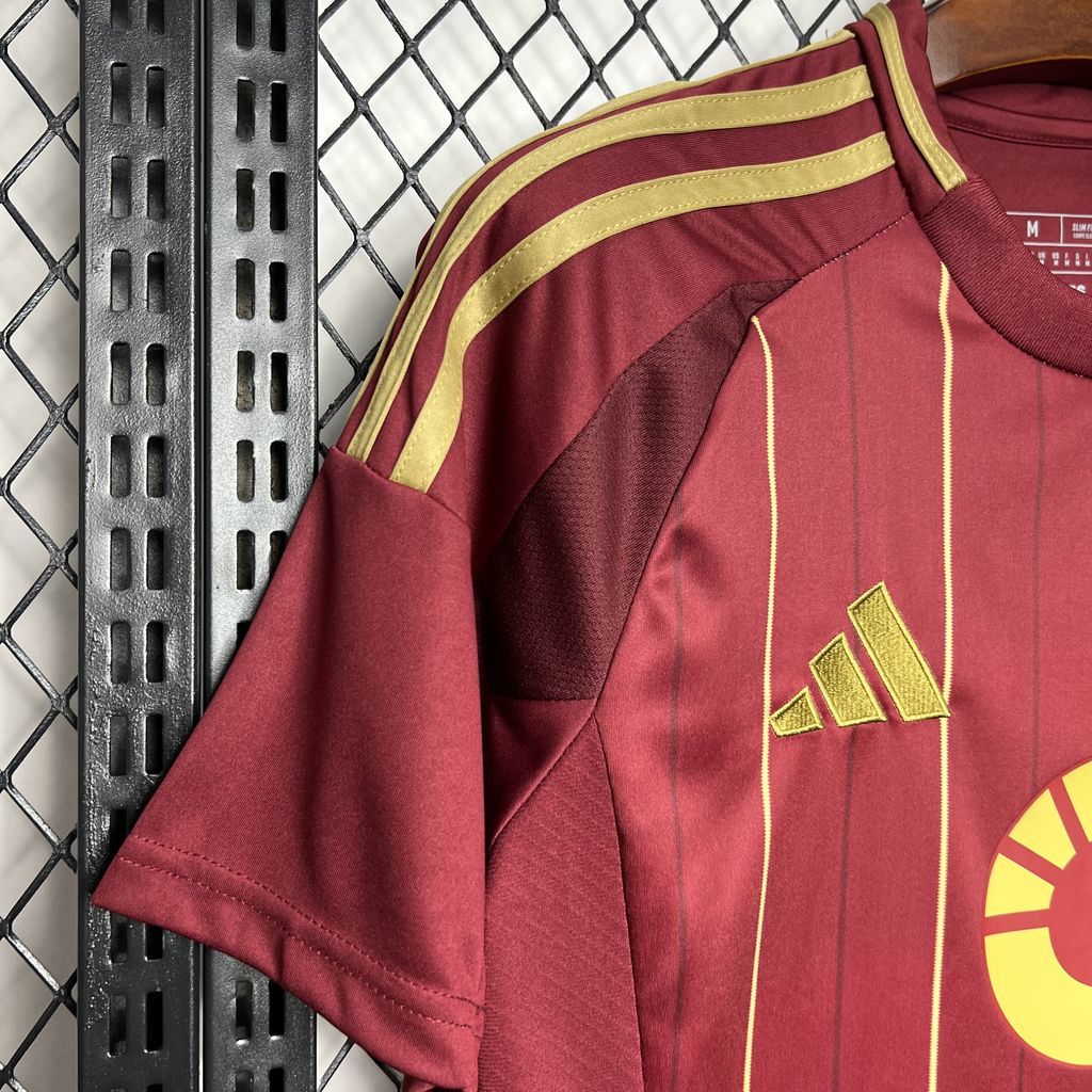 Burgundy Roma jersey sleeve with gold adidas logo and shoulder stripe detail