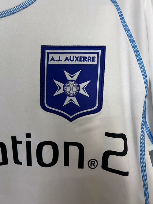 White jersey panel with blue A.J. Auxerre crest patch and blue side piping
