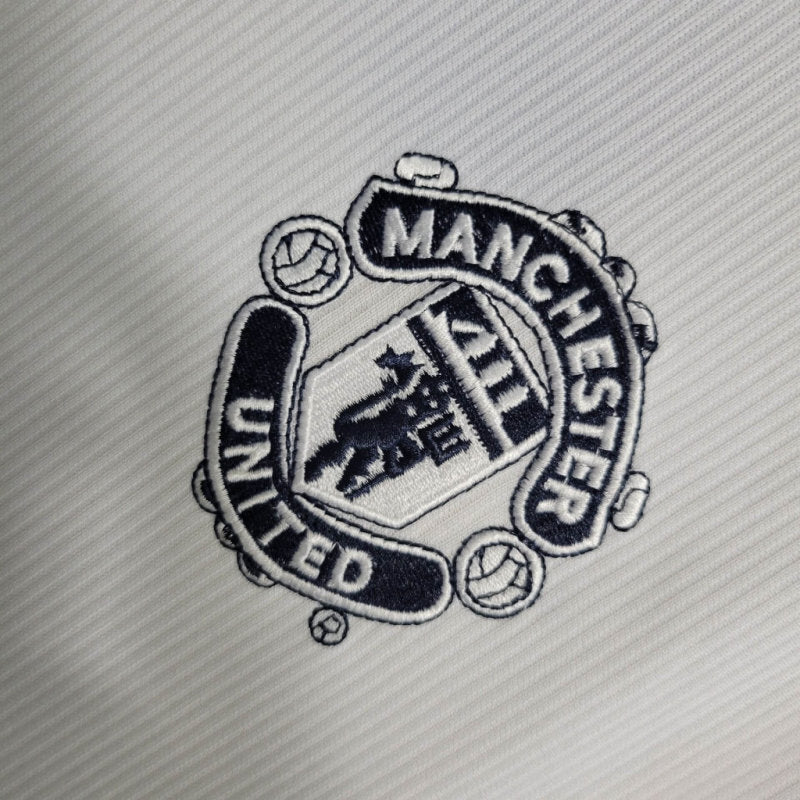 Close-up of Manchester United club crest patch on white jersey