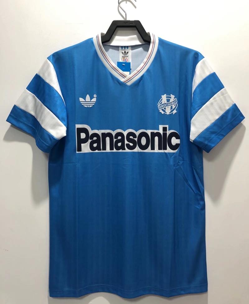 Blue retro soccer jersey with white stripes, V-neck, and Panasonic front sponsor logo