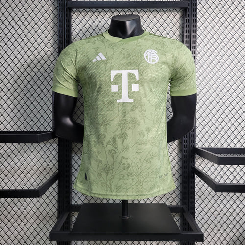 Oktoberfest player jersey in light green with leaf pattern, FC Bayern crest, and white sponsor graphic