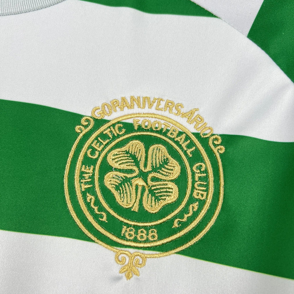 Gold Celtic FC crest on green-and-white striped football shirt